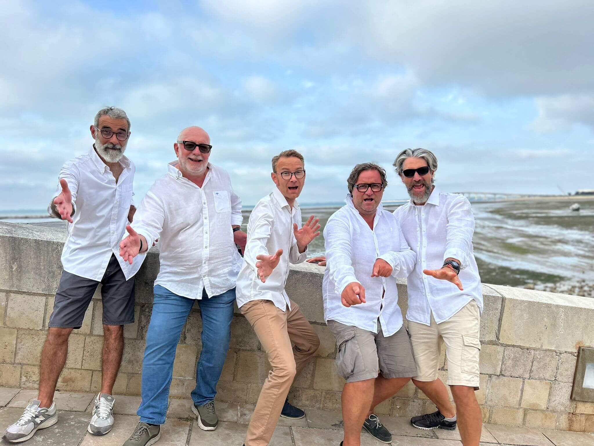 5 hommes en chemises blanche avec la mer en fond